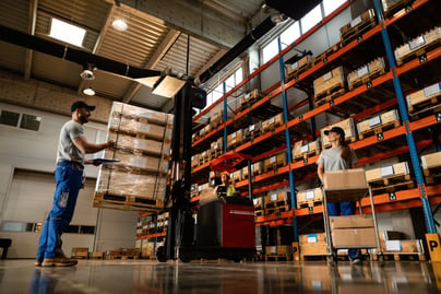 low-angle-view-happy-warehouse-workers-communicating-while-working-with-shipment-industrial-storage-compartment